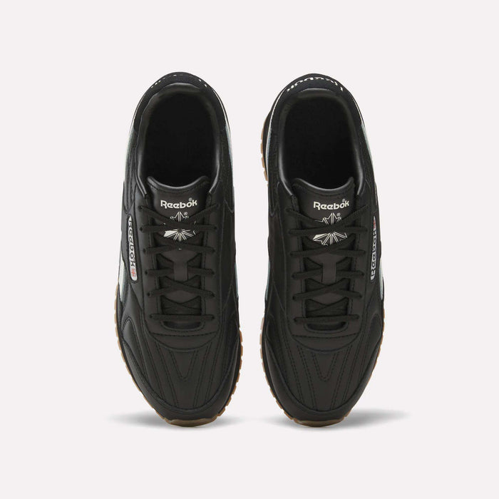 A pair of Reebok Women’s Classic AZ Shoes in black are shown from above, highlighting the laces, Reebok branding on the tongues, and stitched detailing on the uppers. The sneakers are placed side by side on a light background.