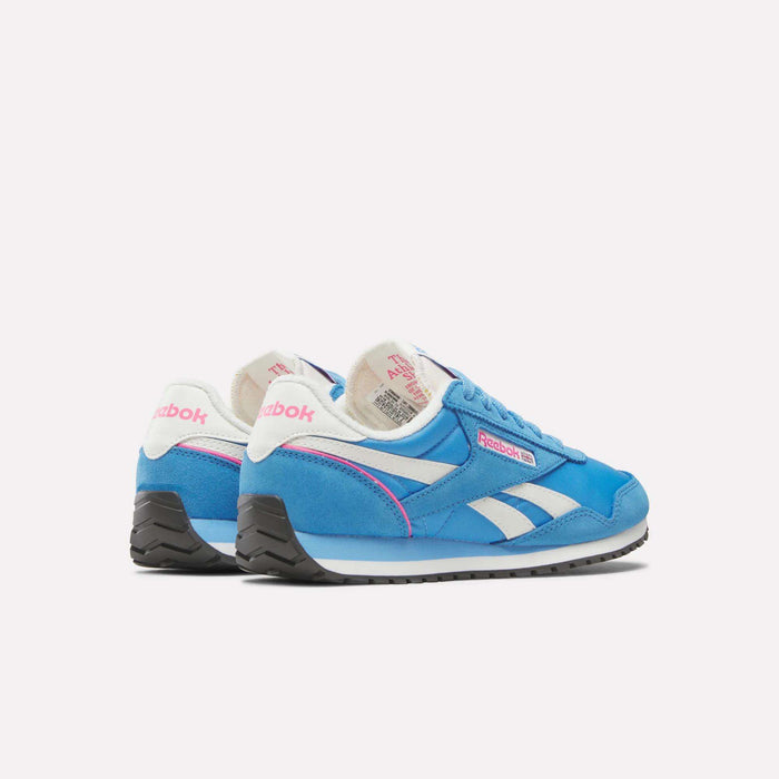 A pair of Reebok Women's Classic AZ Shoes in blue with white and pink accents, white laces, and black soles is displayed on a plain light background, one shoe positioned slightly behind the other.