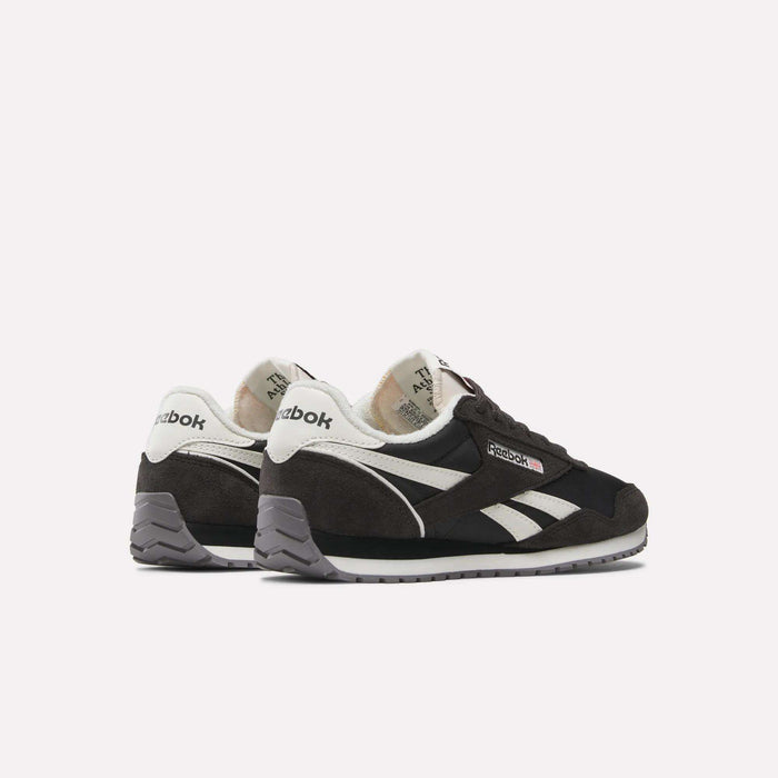 A pair of Women's Classic AZ Shoes by Reebok, featuring black and white colors with suede accents, white side stripes, and rubber soles. Displayed on a light background, one shoe faces forward while the other shows the heel.