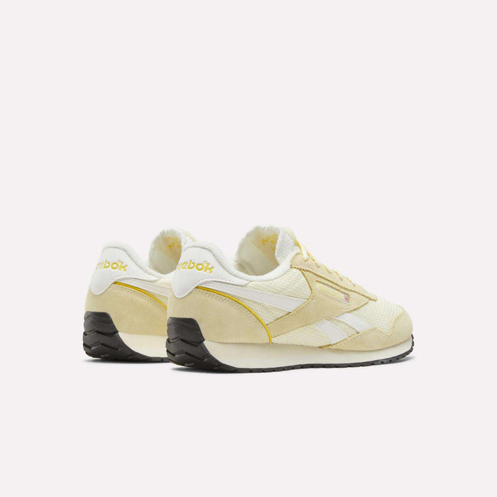 A pair of Women’s Classic AZ Shoes by Reebok in cream and yellow, featuring a crochet textile upper with white accents and black soles, displayed from the back and side on a plain white background.