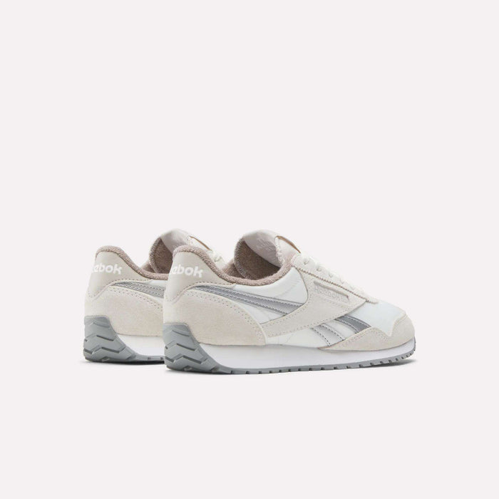 A pair of Reebok Women's Classic AZ Shoes in white and beige with gray accents are shown from a back-side angle, highlighting their timeless vintage style against a plain white background.
