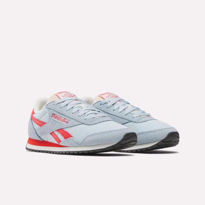 The Women's Classic AZ Shoes by Reebok feature a light blue design with red and white accents, white laces, black soles, and the Reebok logo on the side and tongue, offering a retro running style against a plain white backdrop.
