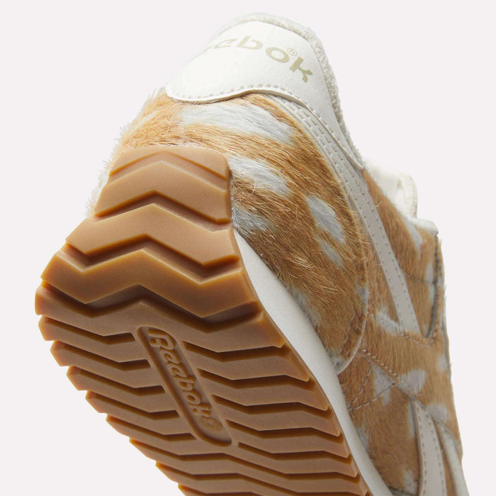 Close-up of Reebok Women's Classic AZ Shoes featuring a tan and white, animal-inspired upper, brown zigzag-patterned rubber sole, and retro Reebok branding on the side and sole.