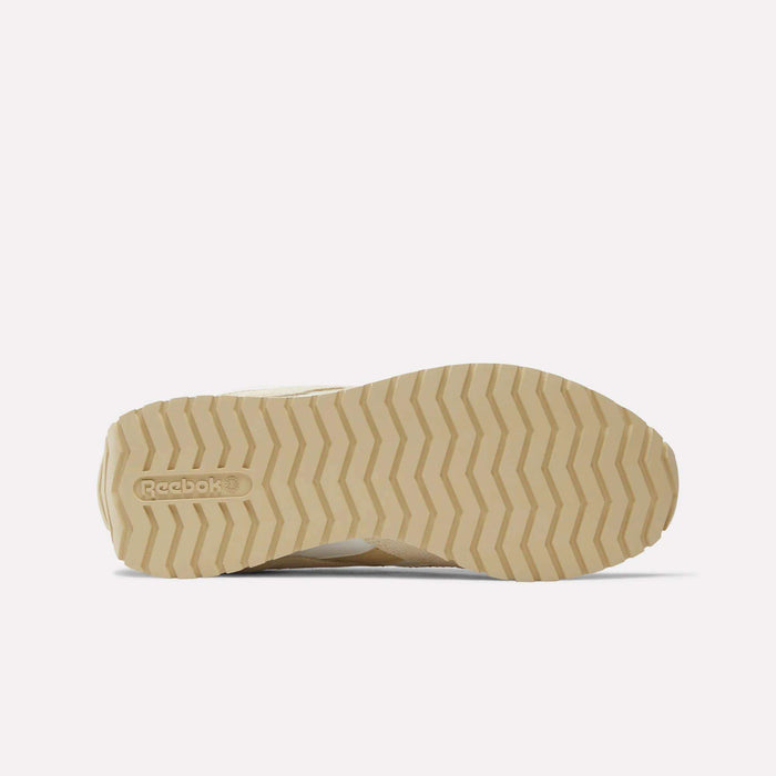 A beige, zigzag-patterned rubber outsole of the Reebok Women’s Classic AZ Shoes is shown from the bottom, featuring an embossed logo near the heel against a plain white background that highlights these sleek runners.