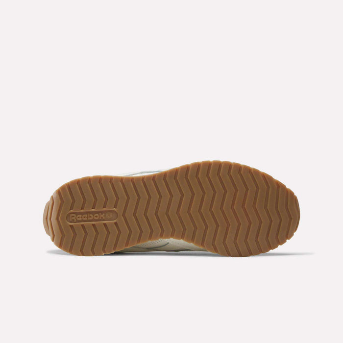 The image displays the sole of a Reebok Women's Classic AZ Shoe, showcasing a gum-colored zigzag tread pattern with the Reebok logo embossed near the heel. Designed for both style and durability, these shoes are part of Reebok's women's collection and typically offer a premium leather upper for enhanced comfort.