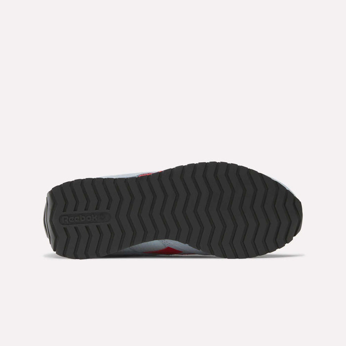 The image shows the bottom view of a Reebok Women's Classic AZ Shoes sneaker, featuring a black zigzag rubber sole with the Reebok logo on the heel. The upper edges are visible, reflecting classic retro running style.