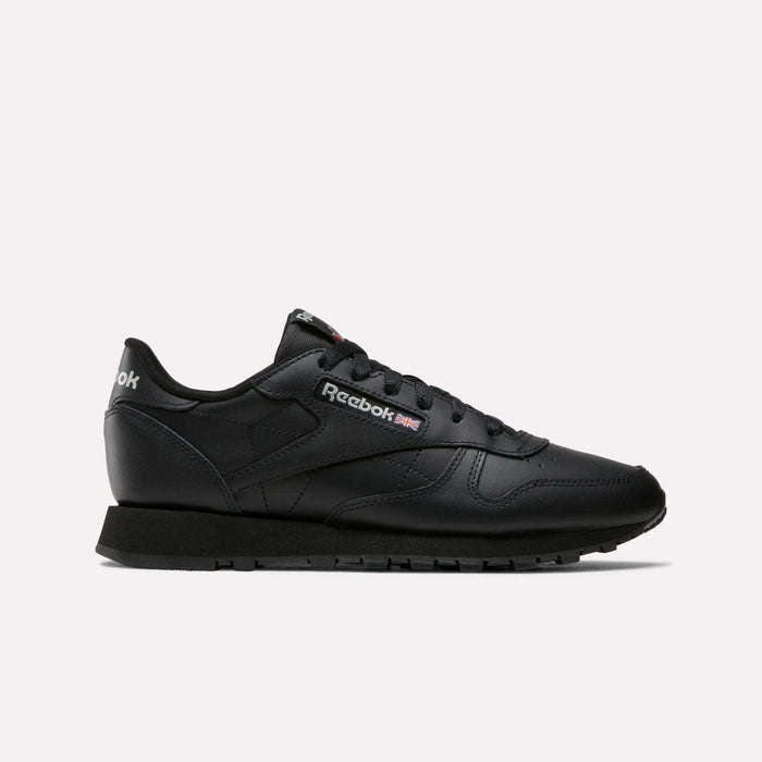 The Reebok Women's Classic Leather Shoes are shown in side profile against a white background, featuring black leather, cushioned midsole, black laces and sole, and the white and red Reebok logo on the side and heel.