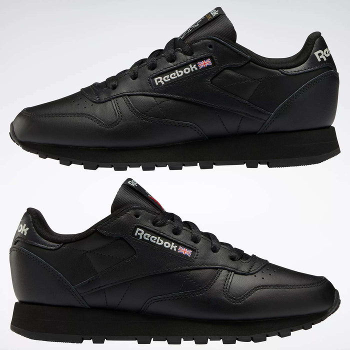 Two black Reebok Women's Classic Leather Shoes are shown in side view, one above the other, on a white background. The cushioned midsole, Reebok logo, and Union Jack flag appear on the sides and heel.