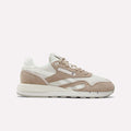 The Women's Classic Nylon 89 Shoes by Reebok feature a retro beige and white design with suede and mesh panels, beige laces, a white sole, and the signature Reebok logo on the side, shown from a side view on a plain white background.