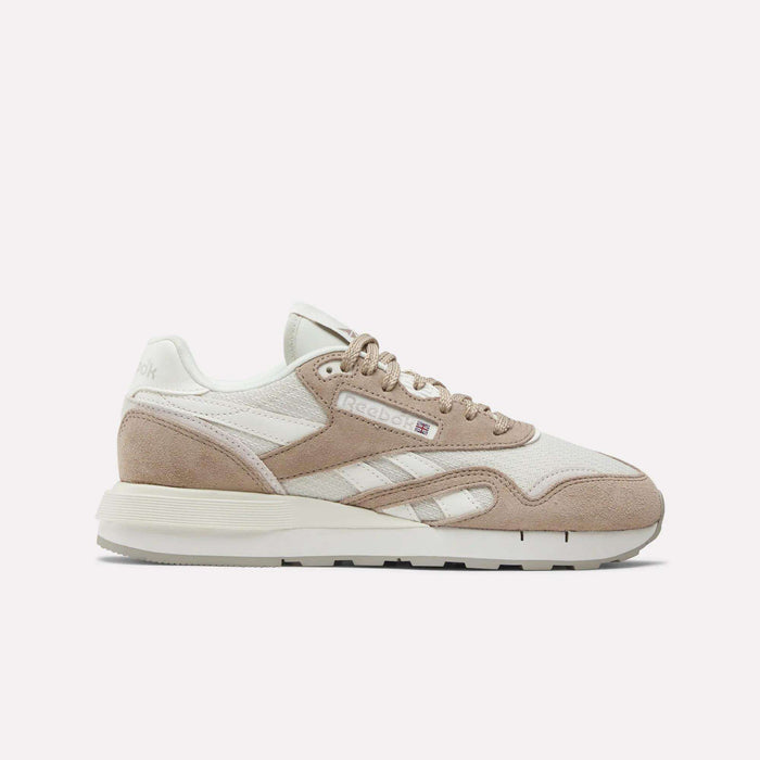 The Women's Classic Nylon 89 Shoes by Reebok feature a retro beige and white design with suede and mesh panels, beige laces, a white sole, and the signature Reebok logo on the side, shown from a side view on a plain white background.