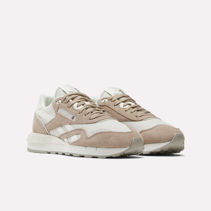The Reebok Women's Classic Nylon 89 Shoes feature beige and white suede and mesh uppers, white midsoles, beige outsoles, and white laces for a retro look, shown against a plain white background.