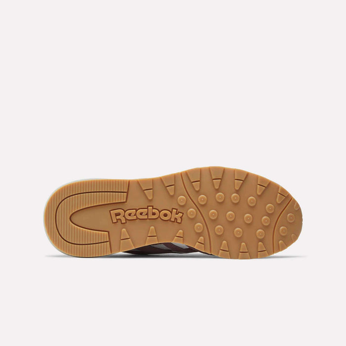 The image shows the gum-colored outsole with circular treads of the Reebok Women's Classic Nylon 89 Shoes, featuring the Reebok logo prominently in the center against a plain white background, highlighting their retro style.