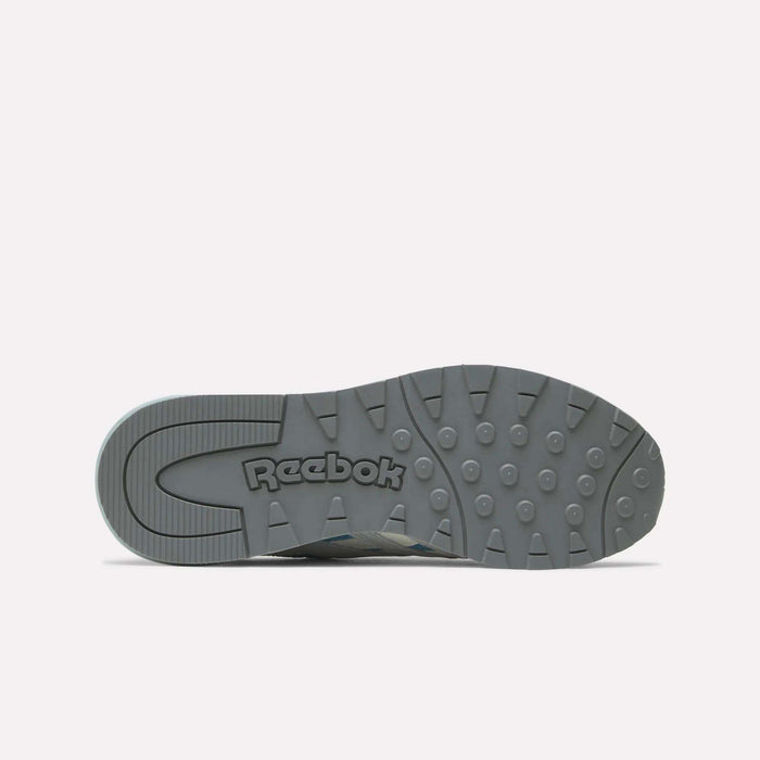 The sole of a gray Reebok Women's Classic Nylon 89 Shoe is shown from the bottom, featuring the Reebok logo and textured tread with circular grips on a white background—ideal for fans of retro style women’s running shoes.