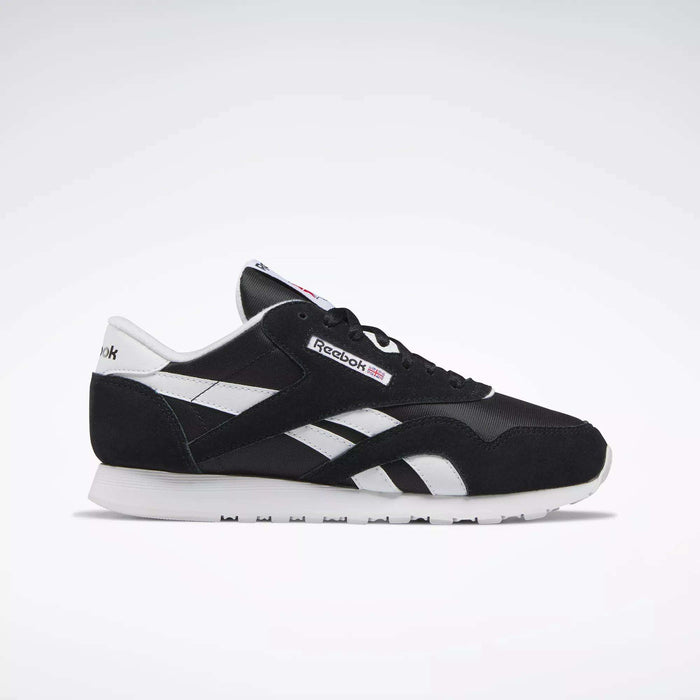 Side view of Reebok Women's Classic Nylon Shoes in black and white, featuring a white sole, black upper, and white details. These iconic sneakers are a versatile everyday choice for women, set against a simple light background.