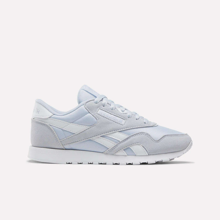 The Reebok Women's Classic Nylon Shoes in Tranquil Blue and White feature a timeless design with a lace-up front, white midsole, and durable rubber outsole—an ideal addition to any women's shoe collection, showcased against a plain white background.