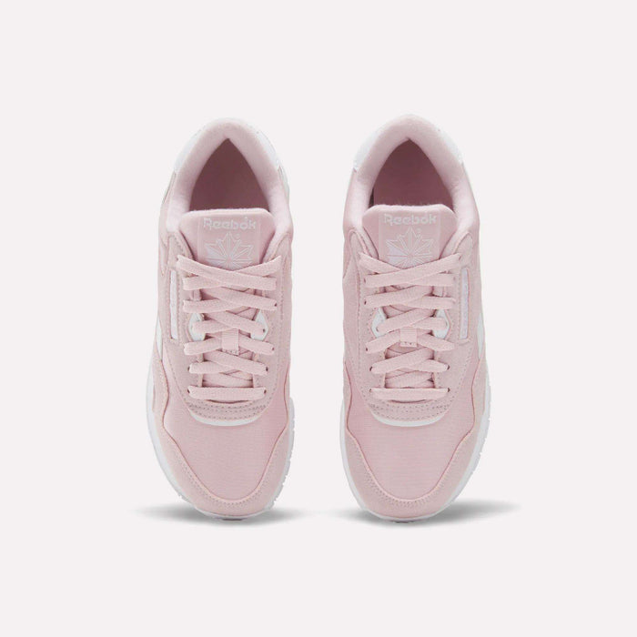 A pair of Reebok Women's Classic Nylon Shoes in light pink is viewed from above, highlighting the laces, tongue with the Reebok logo, and white soles, all set against a plain white background.