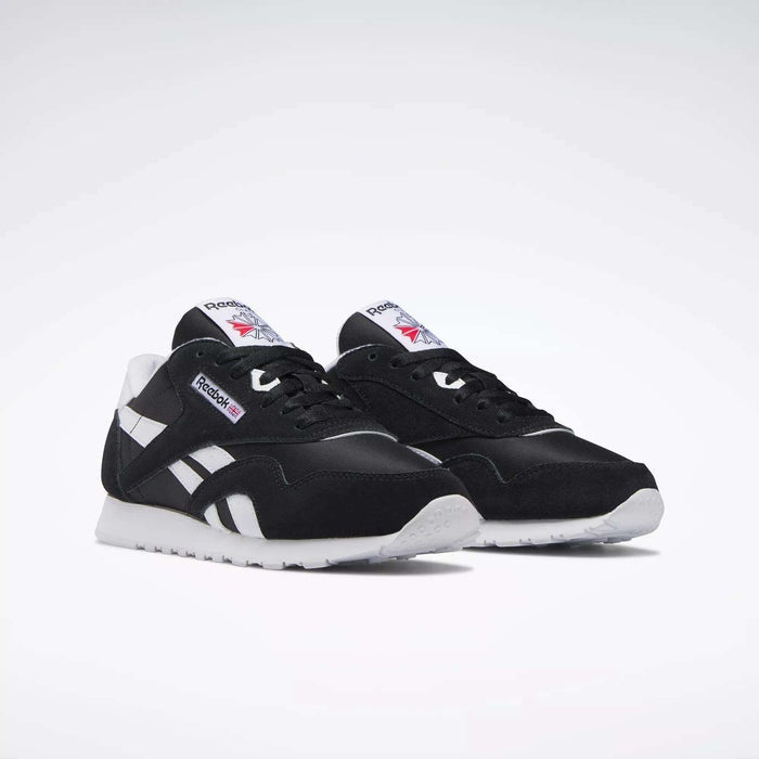 A pair of Women's Classic Nylon Shoes by Reebok in black suede with white soles, side stripes, and tongue labels showing the Reebok logo and Union Jack, ideal as everyday sneakers and shown on a plain white background.