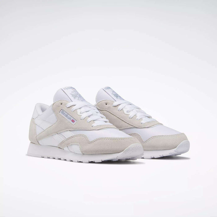 Reebok Women's Classic Nylon Shoes in white with gray suede accents, white laces, and the Reebok logo on the side—stylish everyday sneakers shown on a white background.