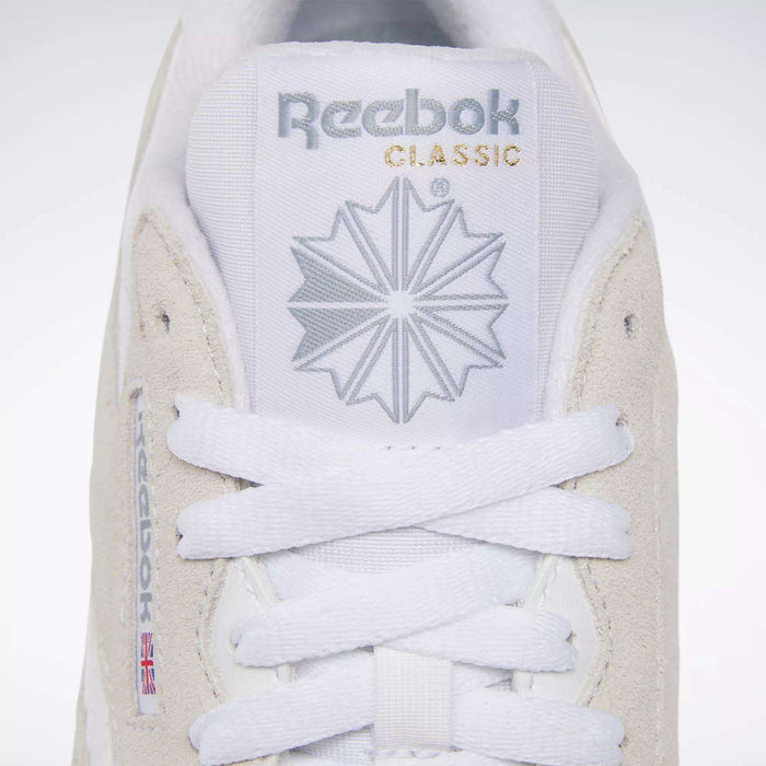 Close-up of the Women's Classic Nylon Shoes from Reebok, featuring the logo, starburst design, and CLASSIC text in gold on the tongue. White laces are neatly tied on this iconic everyday sneaker.