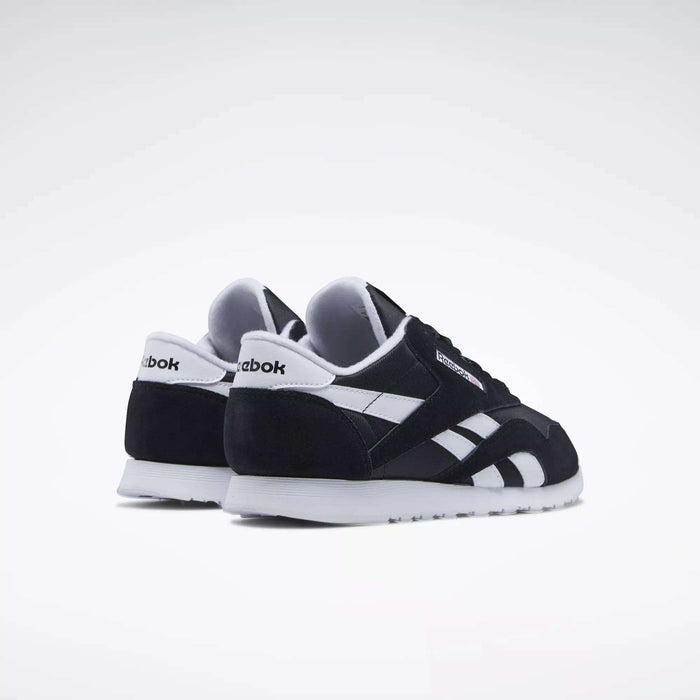 Women's Classic Nylon Shoes by Reebok are shown in black and white on a plain white background, revealing back and side views. With white soles and signature Reebok logos, these sneakers are ideal for stylish everyday wear.