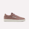 The Reebok Women’s Club C 85 Shoes in Light Cocoa/Chalk feature a mauve pink suede finish with a crisp white sole and classic Reebok branding on the side and tongue. Displayed on a plain white background, these stylish tennis shoes are perfect for women seeking both fashion and comfort.