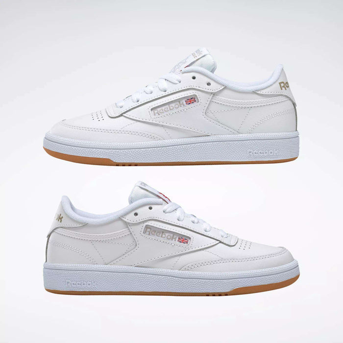 A pair of Reebok Women's Club C 85 Shoes in white with gum soles, side by side, showcasing the Reebok logo and UK flag—classic women's sneakers displayed against a plain white background.