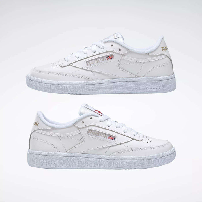 Two Women's Club C 85 Shoes by Reebok are displayed side by side against a plain background, featuring classic white soles and laces with subtle Reebok branding and a small Union Jack flag on the side.
