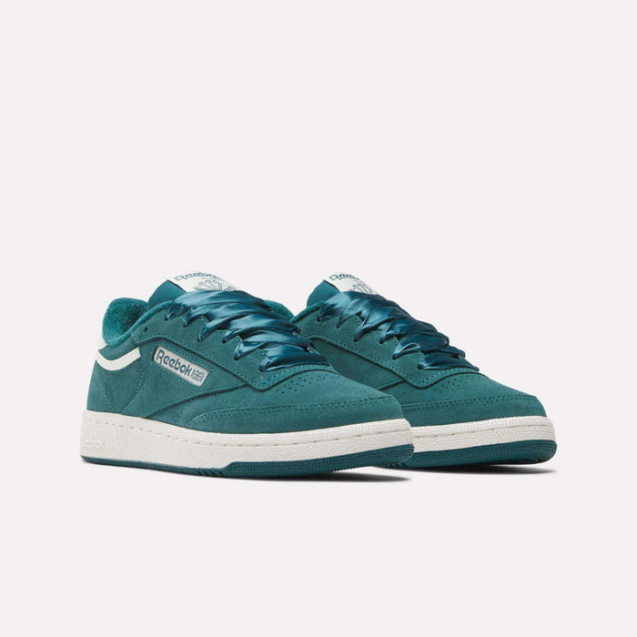 A pair of Women's Club C 85 Shoes by Reebok in teal suede, featuring white midsoles and blue laces, are displayed side by side on a plain white background.