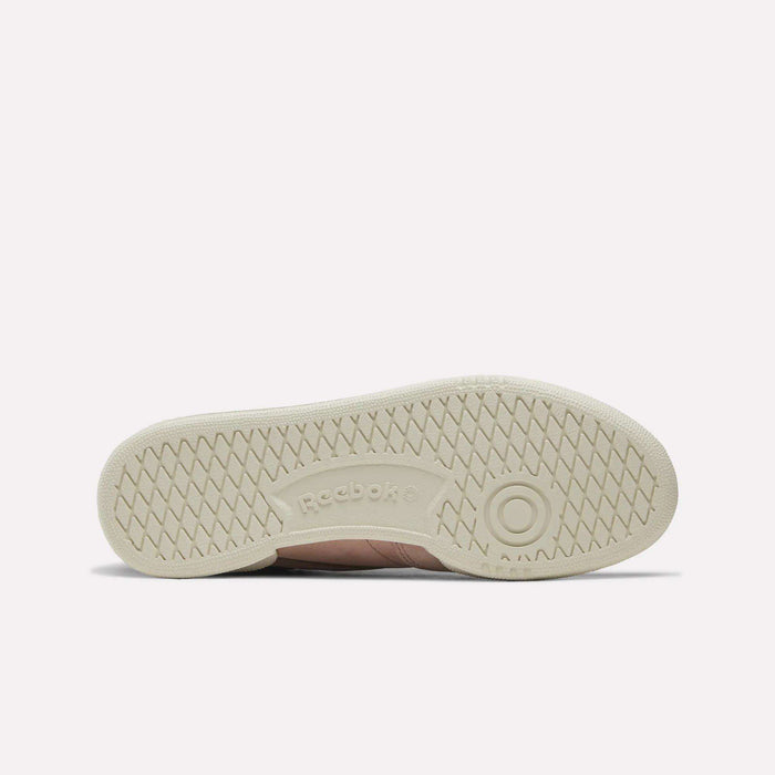 The sole of the Women’s Club C 85 Shoes by Reebok, in beige, features a textured herringbone pattern with the Reebok logo embossed at the center—making it an ideal addition to any women’s tennis shoe collection.
