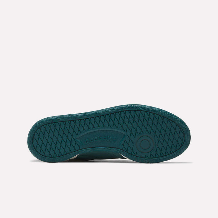 The image shows the sole of a teal Reebok Women's Club C 85 shoe, with a herringbone tread, circular toe grip detail, and the Reebok logo embossed at the center—ideal for women's sneaker enthusiasts.