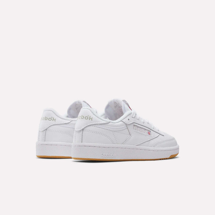 A pair of Reebok Women's Club C 85 Shoes in classic white with light gray accents and a gum sole, displayed on a plain light background—one shoe angled forward, the other facing backward.