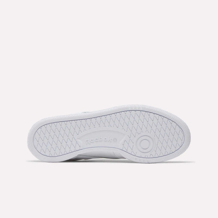 The image displays the sole of the Reebok Women's Club C 85 Shoes, featuring a textured zigzag pattern for grip and an embossed Reebok logo in the center—a timeless design for women.