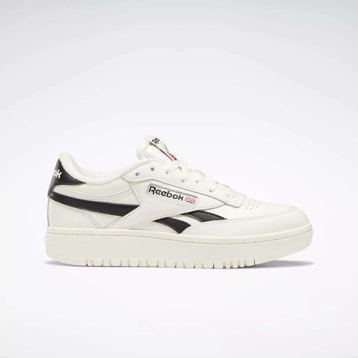 The Reebok Women's Club C Double Revenge Shoes are white with black accents, feature a black Reebok logo and British flag on the side—classic court-inspired style for everyday wear.