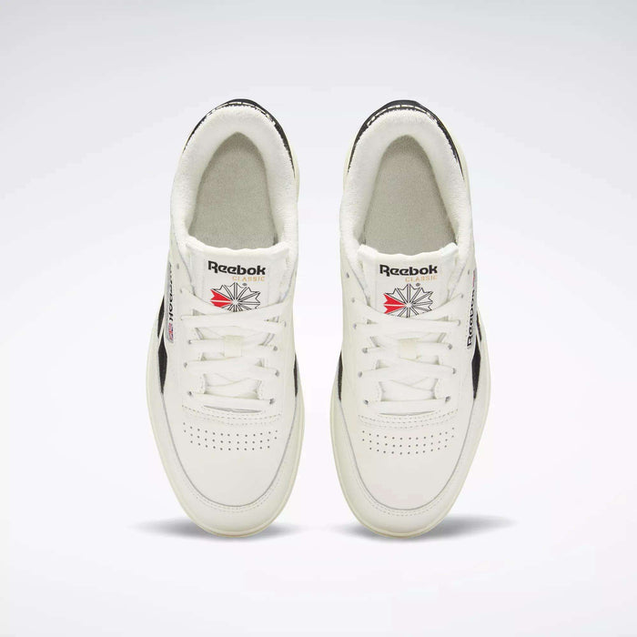 Top-down view of Women's Club C Double Revenge Shoes by Reebok, featuring black accents, double outsole, Reebok logos on the tongue, and perforated toe area, displayed side by side on a light background.