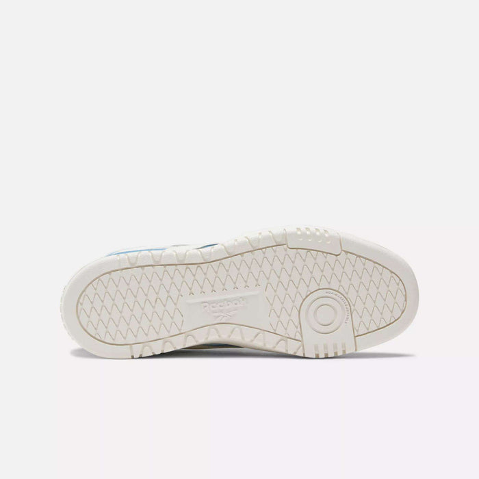 The image shows the white rubber sole of a Reebok Women's Club C Double Revenge Shoe, featuring a geometric tread and embossed Reebok logo in the center, placed sole-up against a plain white background.