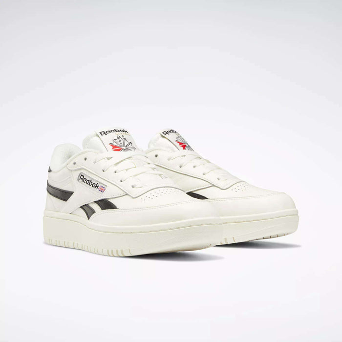 A pair of Women's Club C Double Revenge Shoes by Reebok, with black accents, double outsole, and a red maple leaf on the tongue featuring the Reebok logo, displayed against a plain light background.