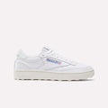 The Reebok Women’s Club C Golf Shoes feature a white upper, cream sole, blue and red side logo, spikeless outsole, and white laces, shown against a plain white background.