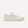 The Reebok Women's Club C Golf Shoes are white and beige low-top, spikeless golf shoes with a textured sole, water-resistant leather upper, lace-up front, and subtle branding on the side and heel. Shown in side profile against a plain background.