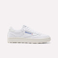 The Reebok Women’s Club C Golf Shoes feature a white upper, cream sole, blue and red side logo, spikeless outsole, and white laces, shown against a plain white background.