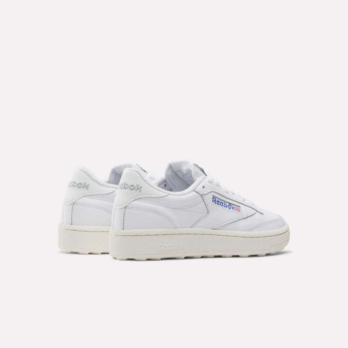 The Women's Club C Golf Shoes by Reebok are classic white sneakers with off-white soles and a spikeless outsole, featuring the Reebok logo on the side and heel. They are photographed against a plain white background.