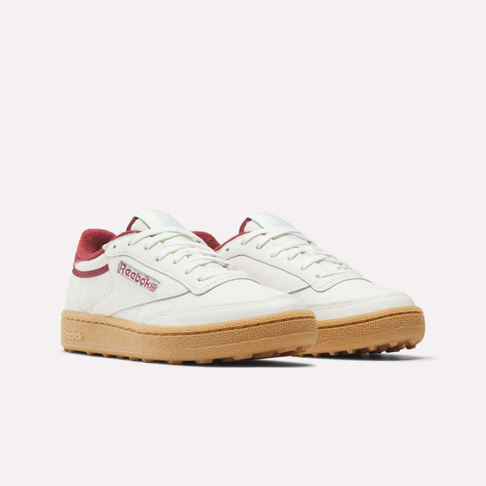 A pair of Women's Club C Golf Shoes by Reebok, featuring white water-resistant leather, maroon accents, and a spikeless outsole, shown on a plain white background.
