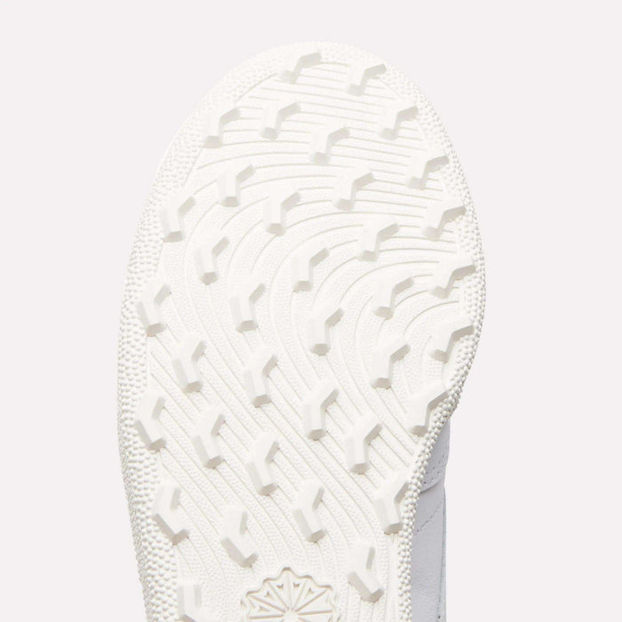 Close-up of the white sole on Reebok Women's Club C Golf Shoes, showing a curved, textured tread with raised angular grips on its spikeless outsole.