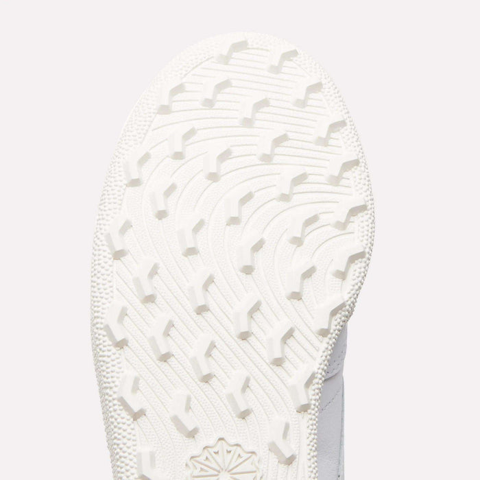 Close-up of the white sole on Reebok Women's Club C Golf Shoes, showing a curved, textured tread with raised angular grips on its spikeless outsole.