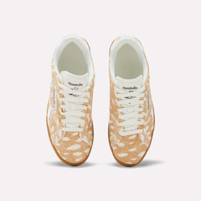 A pair of Women’s Club C Grounds UK 1.0 Shoes by Reebok with a brown and white spotted animal print pattern resembling a fawn’s fur, viewed from above, featuring white laces and a white interior lining.