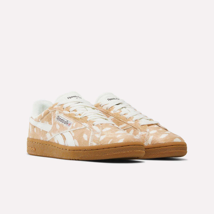 Women’s Club C Grounds UK 1.0 Shoes by Reebok in tan, featuring a white abstract animal print, white laces, a white Reebok logo, and gum soles. The sneakers are displayed side by side, angled slightly to the right on a plain white background.
