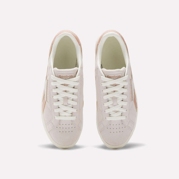 A top view of the Reebok Women's Club C Grounds UK Shoes in light pink, featuring white laces, beige details, suede and leather accents, and the Reebok logo on the tongue.