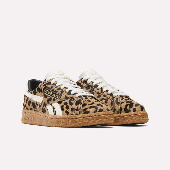 The Women's Club C Grounds UK Shoes by Reebok feature a retro leopard print, white stripes and laces, black accents, and tan rubber soles, shown against a plain white background.