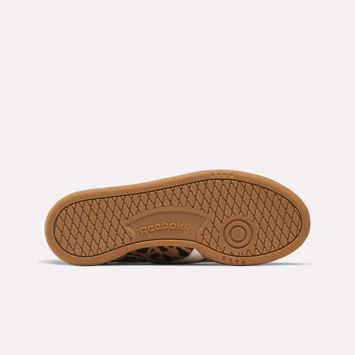 The brown, textured rubber sole of the Reebok Women's Club C Grounds UK shoe features the Reebok logo and a circular grip pattern, displayed against a plain white background.