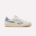 The Reebok Women's Club C Revenge Shoes feature a white design with blue accents, beige sole, and Reebok logos on the side and heel, shown in side profile against a plain white background—ideal for fans of classic women's court shoes.