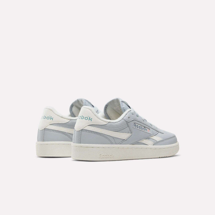 A pair of Women's Club C Revenge Shoes by Reebok in light gray and white features teal Reebok logos on the side and heel, evoking vintage court style for a timeless appeal. These women's casual shoes are displayed against a plain white background.